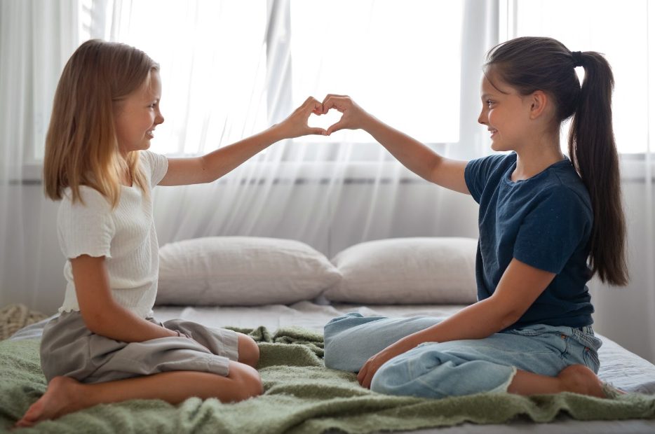 Две сестри правят сърце с ръцете си