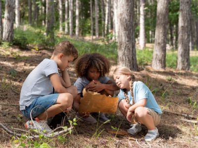 Деца от лагера ЛъкиКидс разучават карта по време на разходка в планината.