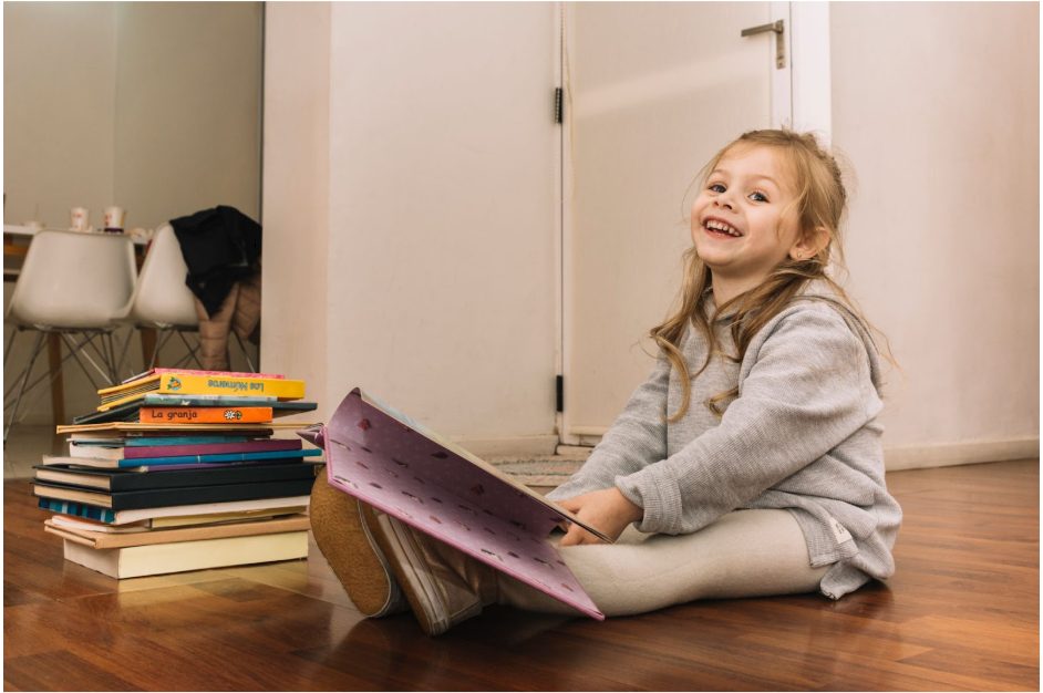 Дете разглежда книги на пода