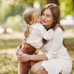 Малко момиче, прегърнало майка си