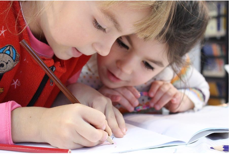 Две деца рисуват в тетрадка.