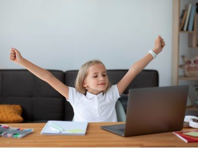 Момиче е щастливо с вдигнати ръце по време на онлайн урок