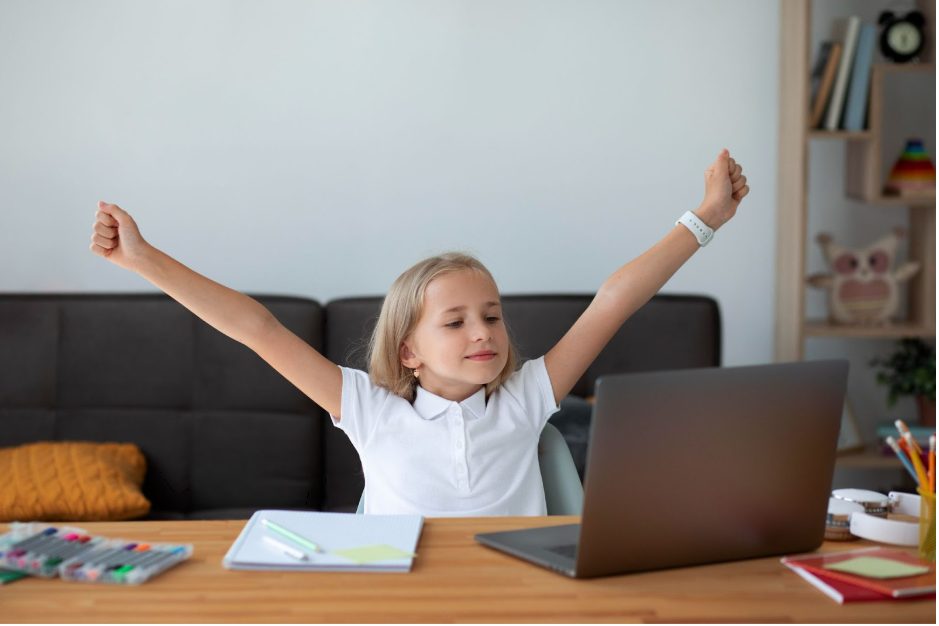Момиче е щастливо с вдигнати ръце по време на онлайн урок